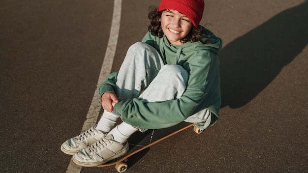 Hoge hoek van tiener met skateboard buitenshuis