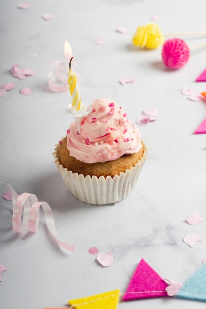 Hoge hoek van verlichte kaars in verjaardag cupcake