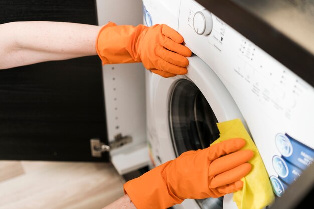 Hoge hoek van vrouw die de wasmachine schoonmaakt