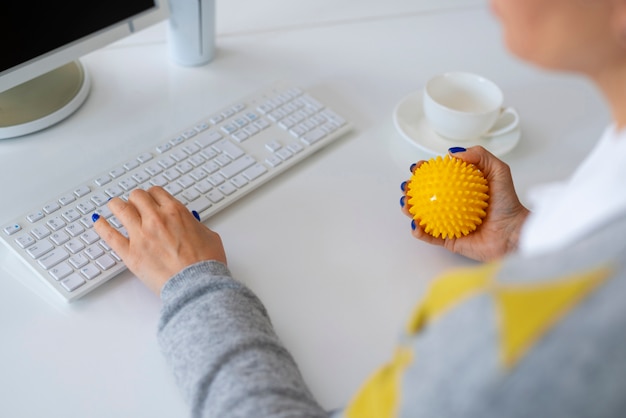 Gratis foto hoge hoek vrouw die bal gebruikt om uit te rekken