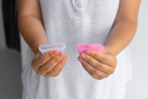 Hoge hoek vrouw die menstruatiecups vouwt