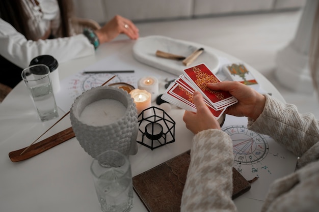 Gratis foto hoge hoek vrouw die tarot thuis leest