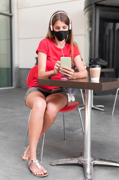 Hoge hoek vrouw op terras met masker