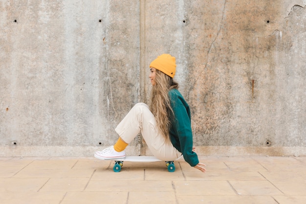 Hoge hoek vrouw rijden skateboard