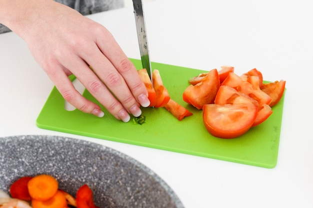 Hoge hoek vrouw snijden tomaten