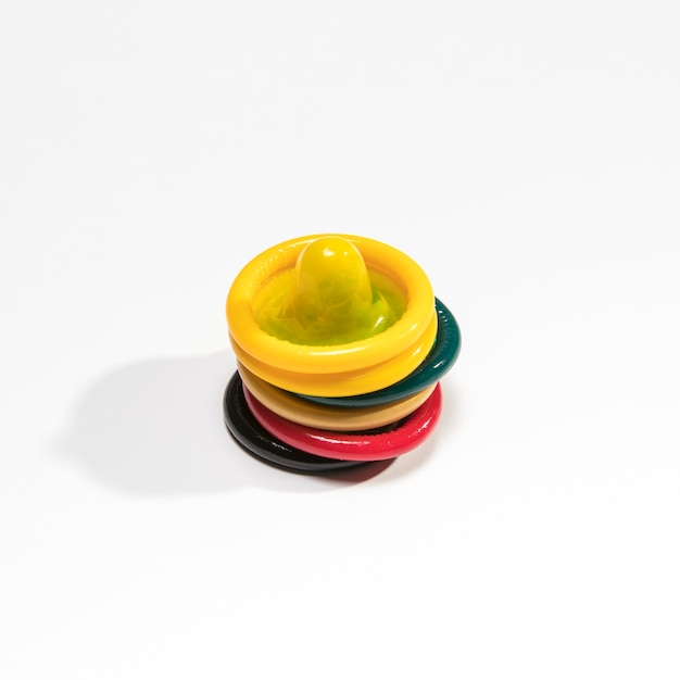 Hoge hoeken kleurrijke condooms op witte achtergrond