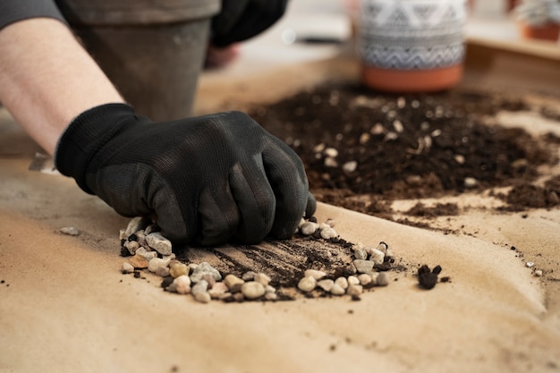 Hoge hoekhand met handschoen die kiezelstenen houdt