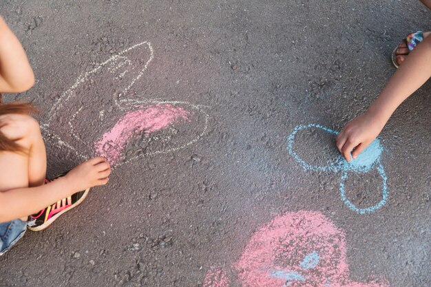 Hoge hoekkinderen die tekening met krijt maken