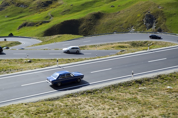 Hoge hoekmening van auto's op de bochtige weg omgeven door heuvels bedekt met groen in Zwitserland