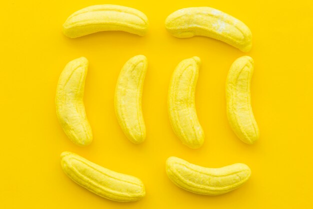 Hoge hoekmening van banaan gevormd suikergoed op gele achtergrond