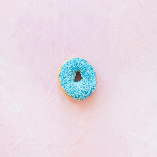 Hoge hoekmening van blauwe doughnut op roze achtergrond