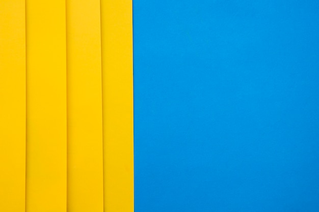Hoge hoekmening van gele craftpapers op blauwe achtergrond