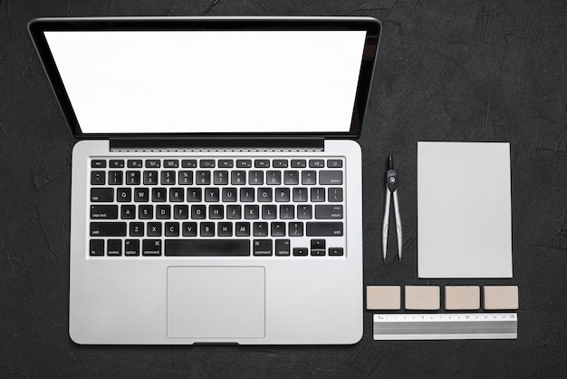 Hoge hoekmening van laptop en kantoorbehoeften op zwarte achtergrond