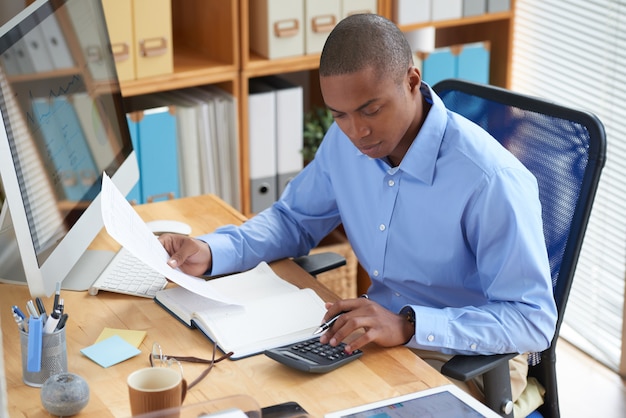 Hoge hoekmening van mannelijke accountant die financieel document controleert