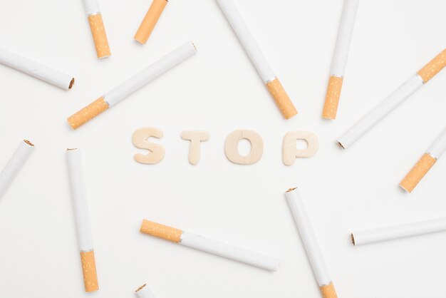Hoge hoekmening van stop tekst en sigaretten op witte achtergrond