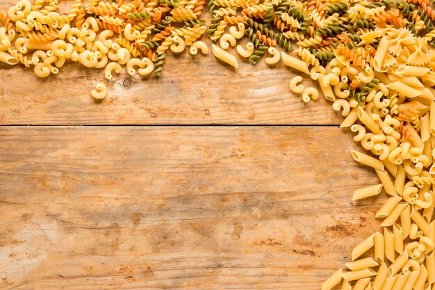 Hoge hoekmening van verschillende soorten ongekookte pasta op houten bureau