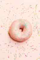 Gratis foto hoge hoekmening van zoete donut omringd door kleurrijke hagelslag