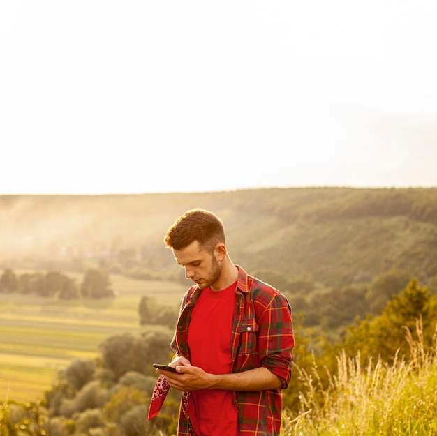 Hoge hoekmens op berg met mobiel