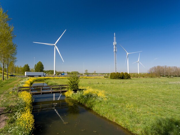 Hoge hoekopname van windturbines nabij de snelwegen en weilanden vastgelegd in Nederland