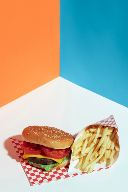Gratis foto hoge hoekopstelling met smakelijke cheeseburger en friet