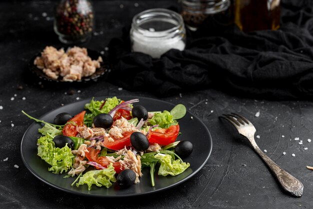 Hoge hoeksalade met verschillende ingrediënten op donkere plaat