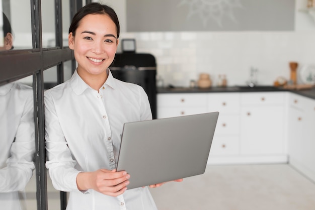 Hoge hoekvrouw die aan laptop werkt