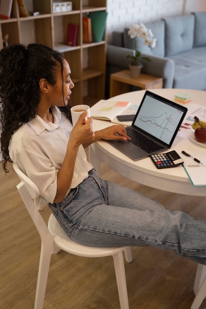 Hoge hoekvrouw die aan laptop werkt