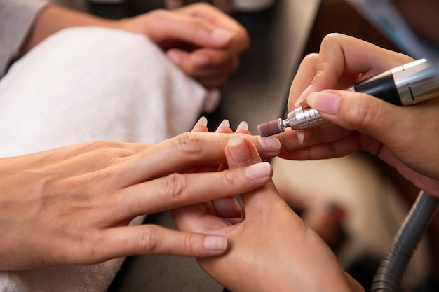 Hoge hoekvrouw die een manicure krijgt