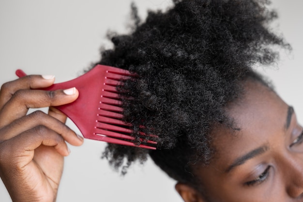 Gratis foto hoge hoekvrouw die haar kamt