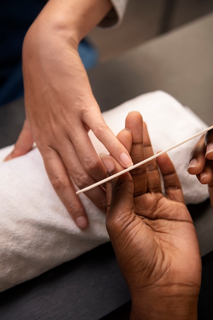 Gratis foto hoge hoekvrouw die manicure krijgt