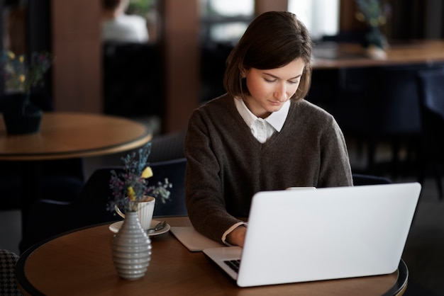 Gratis foto hoge hoekvrouw die met laptop werkt