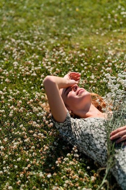 Hoge hoekvrouw die op gras legt