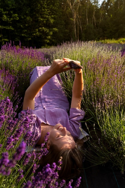 Hoge hoekvrouw die op lavendelveld legt