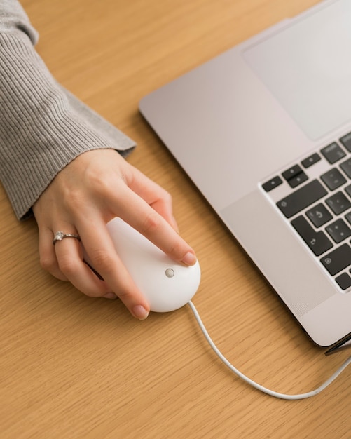 Gratis foto hoge hoekvrouw op laptop die muis gebruikt