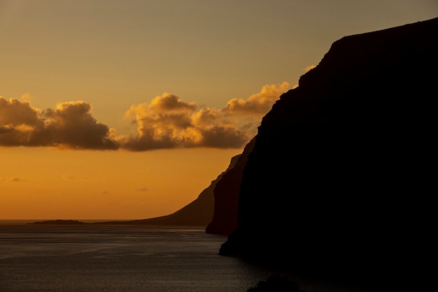 Gratis foto hoge klif aan de kust bij de zonsondergang