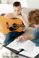 Gratis foto hoge mening tutor en jongen gitaar spelen