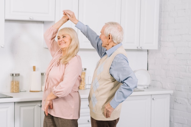 Hoger paar die in keuken dansen