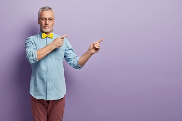 Hogere mens in denimoverhemd en gele bowtie