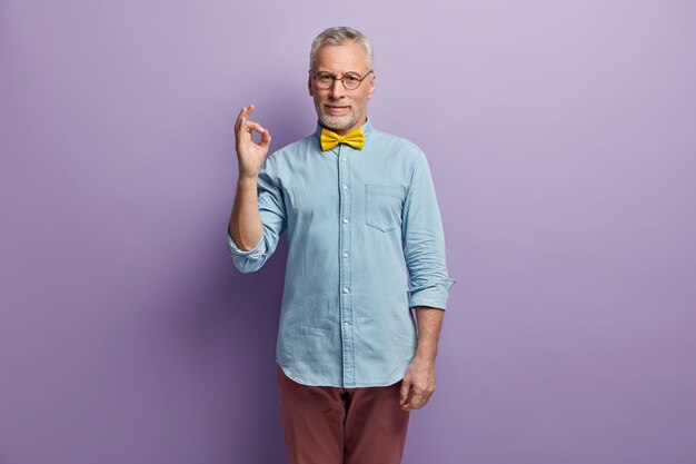 Hogere mens in denimoverhemd en gele bowtie