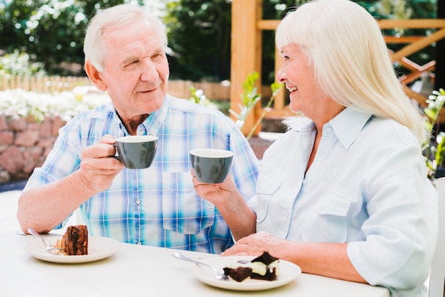 Hogere paar het drinken thee op in openlucht veranda