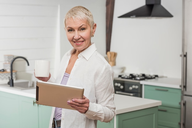 Hogere vrouw die een tablet houdt