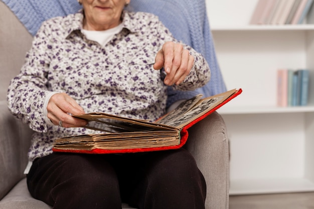 Gratis foto hogere vrouw die fotoalbum onderzoekt