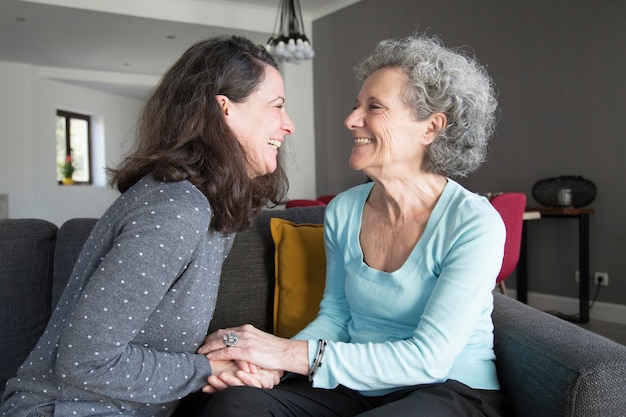 Hogere vrouw en haar dochter die pret hebben en handen houden