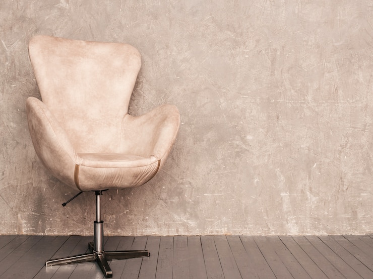 Gratis Foto home interieur grijze muur achtergrond met beige fluwelen fauteuil en houten vloer