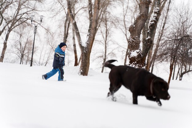 Hond spelen met kind in de sneeuw met familie