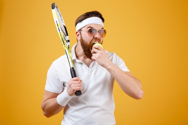 Hongerige jonge tennisbeet bijten tennisbal.