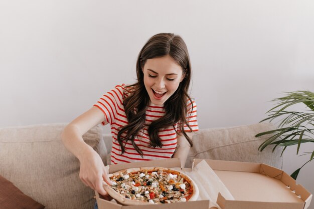 Hongerige vrouw wachtte op haar bestelling en is klaar om nog een hete pizza te eten