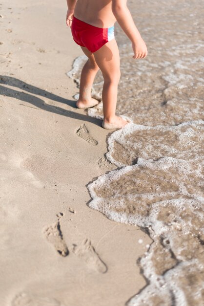 Gratis foto hoog bekijken kind spelen door de kust