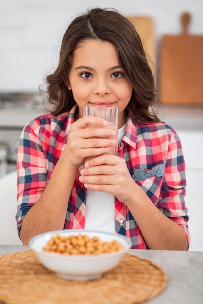 Hoog hoekmeisje die vers sap drinken bij ontbijt