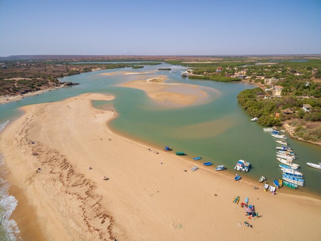 Hoog schot van stranden omgeven door cruiseschepen en groen onder een blauwe hemel in Senegal